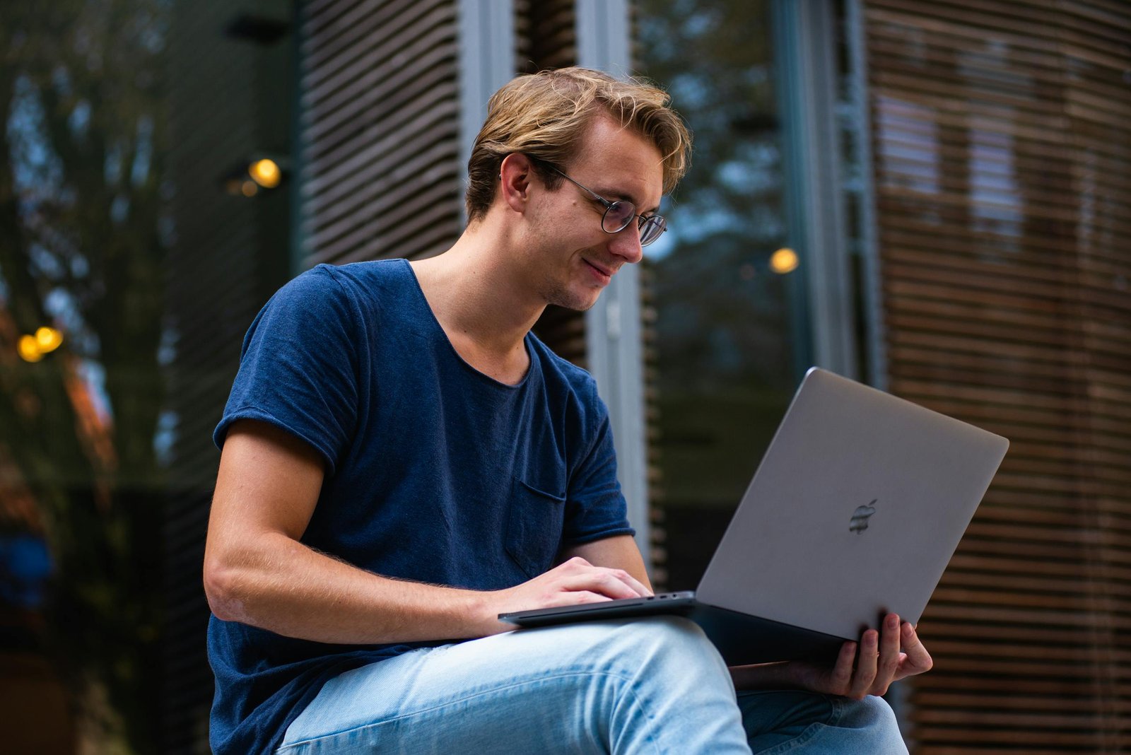 young man sitting outdoors working laptop and passive income website