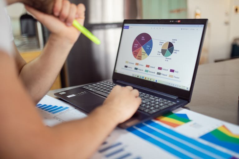 Person analyzing financial charts and graphs on a laptop us Rank Math Plugin