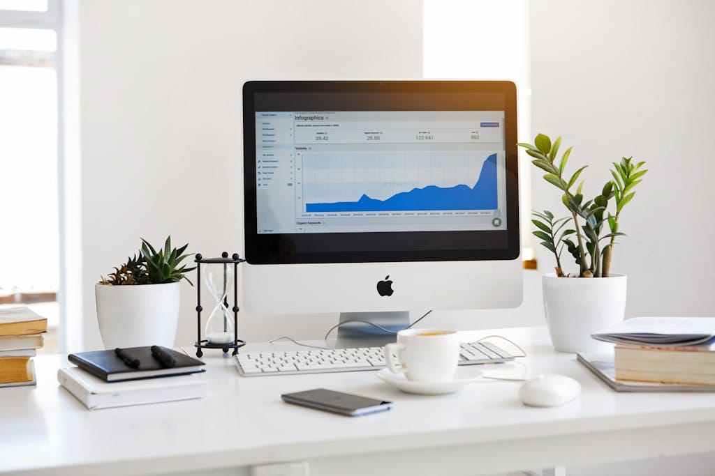 A clean, contemporary workspace featuring a desktop with affiliate marketing dashboard on the screen and plants for a fresh look.