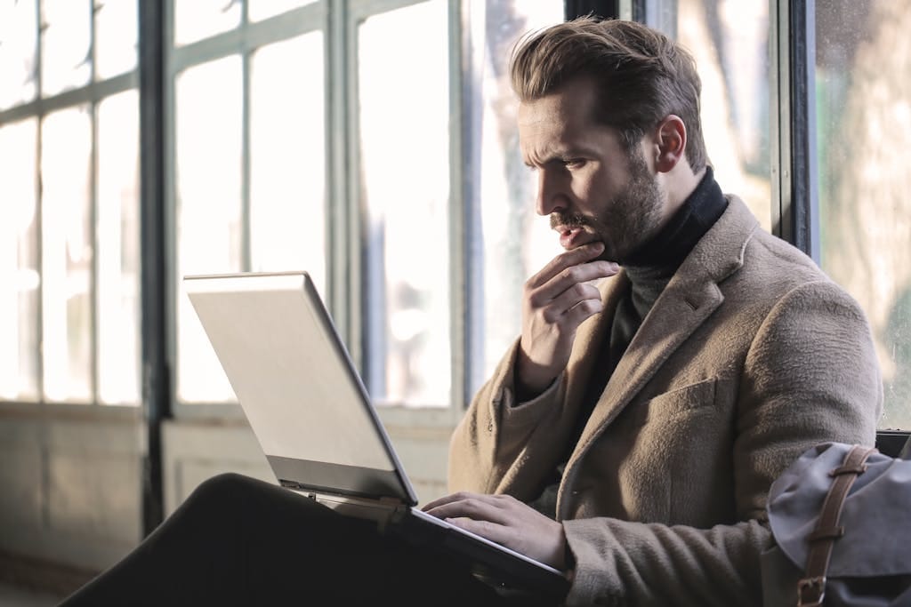 Man looking contemplative while working on a ai seo in a well-lit indoor.